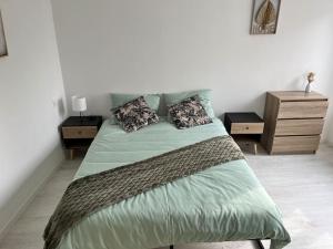 a bedroom with a large bed with two night stands at Maison centre ville Ardres in Ardres