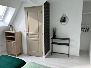 a bedroom with a white door and a table at Maison centre ville Ardres in Ardres