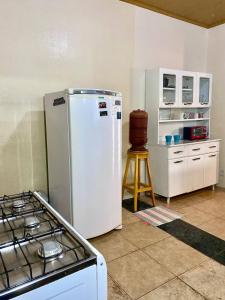 a kitchen with a stove and a white refrigerator at Private Cosmic VILLA! 2 Homes, Yoga Room & JACUZZI! in Alto Paraíso de Goiás +33 photos