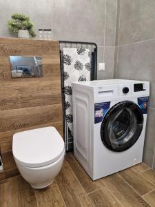 ein Badezimmer mit Waschmaschine und Toilette in der Unterkunft Apartament Bałtycka & Bike Room in Kołobrzeg