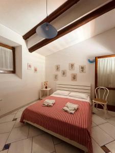 une chambre avec un grand lit recouvert d'une couverture rouge dans l'établissement villa Il Gelsomino, à Termini