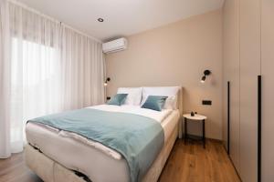 a bedroom with a large bed and a window at 88 TREES Luxury Apartment in Malinska