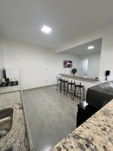 - une chambre avec des chaises et un bar dans l'établissement Executivo Veneza 303, à Ipatinga