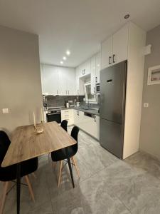 a kitchen with a wooden table with chairs and a refrigerator at Amela House in Skala Kallirachis +14 photos