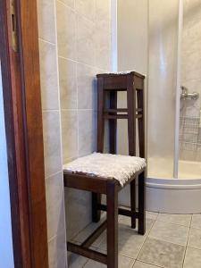un tabouret en bois assis dans une douche dans une salle de bain dans l'établissement Vila Klara- Blue room, à Olib