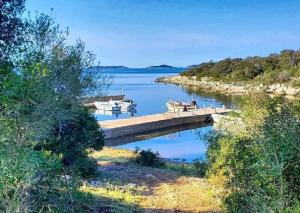 a dock with two boats on a body of water at Vila Klara- Blue room in Olib