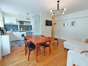a kitchen and living room with a wooden table and a dining room at L'appart du Maupas, T3, wifi, parking in Luchon