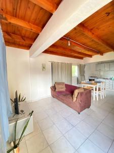 Una sala de estar con un sofá y una cocina. en Ale's Apartments - Puerto Iguzú, Misiones, en Puerto Iguazú
