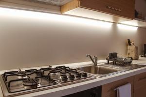 a kitchen with a stove and a sink at Appartamento Maniero 55 in Domaso