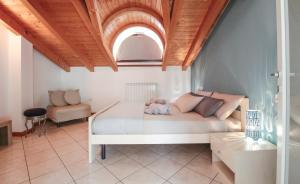 a bedroom with a white bed with a wooden ceiling at Appartamento Maniero 55 in Domaso