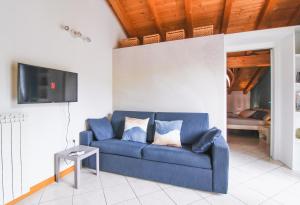 a blue couch in a living room with a tv at Appartamento Maniero 55 in Domaso