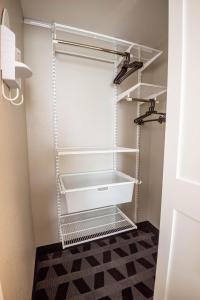 a walk in closet with white shelves at TownePlace Suites Columbus Airport Gahanna in Gahanna +34 photos