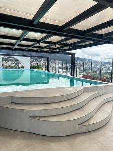 a swimming pool with a view of a building at Suite de Lujo Piscina Hidromasaje in Quito