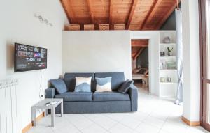 a living room with a blue couch and a table at Appartamento Maniero 55 in Domaso