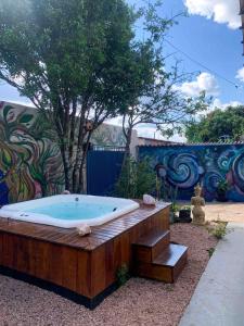 a jacuzzi tub in a garden with a mural at 3BR, 3BA Cosmic Home Sleeps 12! With a Lux Jacuzzi in Alto Paraíso de Goiás