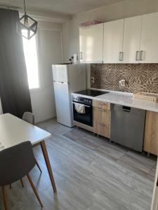 kuchnia z kuchenką, lodówką i stołem w obiekcie Apartment studio 30 w Sarajewie +3 zdjęcia