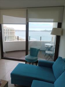 a living room with a couch and a view of the ocean at Departamento JARDIN DEL MAR, 2 Dormitorios in Coquimbo