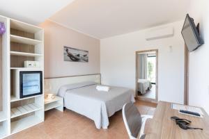 a small room with a bed and a television at Hotel MARINELLA parking wi-fi spiaggia attrezzata in Capo Vaticano