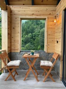 a patio with a table and two chairs and a window at Dağhan Bungalov in Çamlıhemşin
