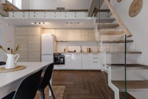 a kitchen with white cabinets and a table and chairs at Hill Garden Terrace in Palanga