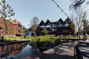 a building with a pond in front of it at Hill Garden Terrace in Palanga