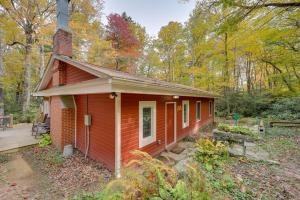 a small red house in the woods with a porch at Creekside Newland Cabin about 7 Mi to Linville Falls in Newland