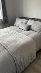 a bed with a pillow on it in a bedroom at Castle View Cottage - Entire Home in Ballynasare