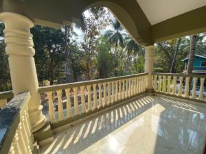 a porch with a white fence and a swimming pool at Gonsalves Villa in Cansaulim