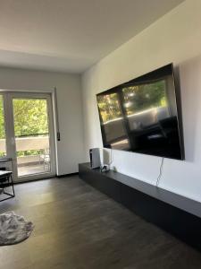 a living room with a large flat screen tv on the wall at Ferienwohnung am Schwimmbad in Bad Bergzabern