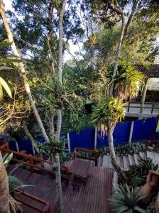 a wooden deck with benches and palm trees at Apart 4 Costa E in Bombinhas