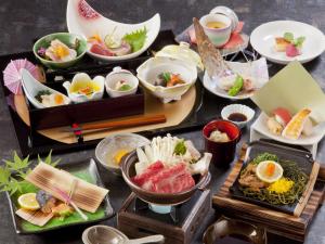 una mesa cubierta con diferentes tipos de comida en platos en Yufuin Besso Shikisai Hotel, en Yufu