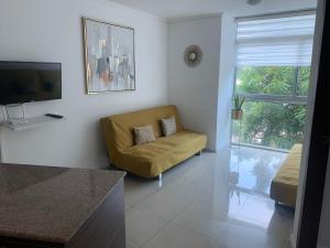 un soggiorno con sedia gialla e TV di Ecusuites Family Depto Resort Riverfront Gye a Guayaquil
