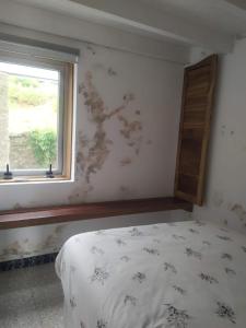 a bedroom with a bed and a window at A Cascada do Ézaro in Dumbría