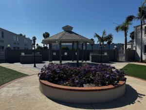 卡森Studio 6 Suites Carson, CA的花园里有紫色花朵的凉亭