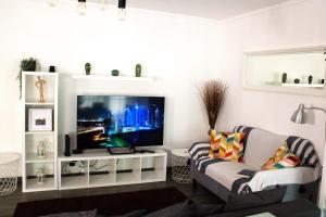 a living room with a tv and a couch at Casa da Avó Bé in Portalegre
