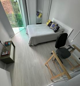 Ένα ή περισσότερα κρεβάτια σε δωμάτιο στο Suíte Conforto com AR, TV e sacada em Florianópolis +23 φωτογραφίες