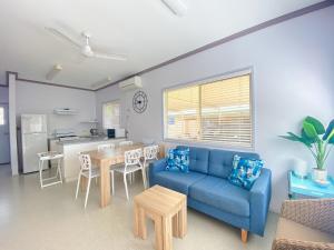 un soggiorno con un divano blu e un tavolo di San Marco Villa 3 - Burrum Heads - Beachfront - 2BR - Pool a Toogoom