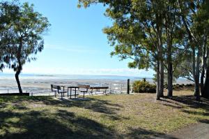 un gruppo di panchine sedute vicino all'oceano di San Marco Villa 3 - Burrum Heads - Beachfront - 2BR - Pool a Toogoom