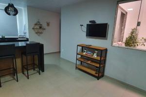 a living room with a television and a table and chairs at 50m da praia de Itaipava, 8km Piúma, 15 km Iriri in Itapemirim