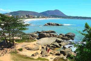 a beach with a group of people on the rocks at 50m da praia de Itaipava, 8km Piúma, 15 km Iriri in Itapemirim