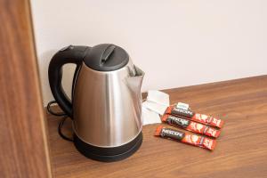 a coffee pot on a table next to some cinnamon sticks at Trpeza Luxury Apartments, free parking in Niš