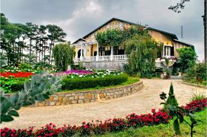 a house with flowers in front of it at Dalat Cadasa Resort in Da Lat