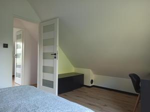 a bedroom with a bed and a stair case at Dom w lesie in Przytuły