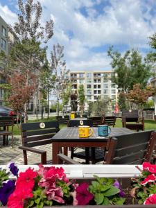 a table and benches with flowers in a park at AME Summer - Onix Blue Mamaia Nord in Mamaia Nord