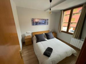 a bedroom with a bed with a black bag on it at Apartamento DALIA in La Molina