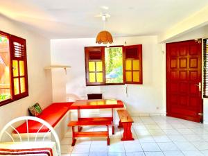 Habitación con mesa y puerta roja en Résidence Les Ziottines, en Deshaies