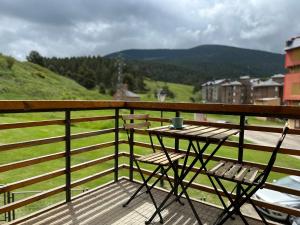 a table and two chairs on a balcony with a view at Apartamento DALIA in La Molina