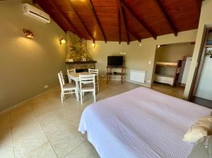 a bedroom with a bed and a table and a fireplace at Curahue Apart Hotel in Tandil +47 photos