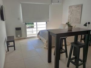 a bedroom with a table and a bed with a window at Monoambientes MOKA in Concepción del Uruguay