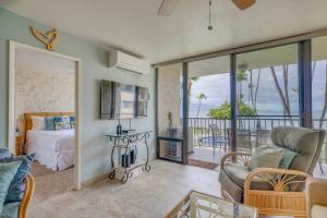 ein Wohnzimmer mit einem Bett und Meerblick in der Unterkunft Kanai A Nalu 310 in Wailuku